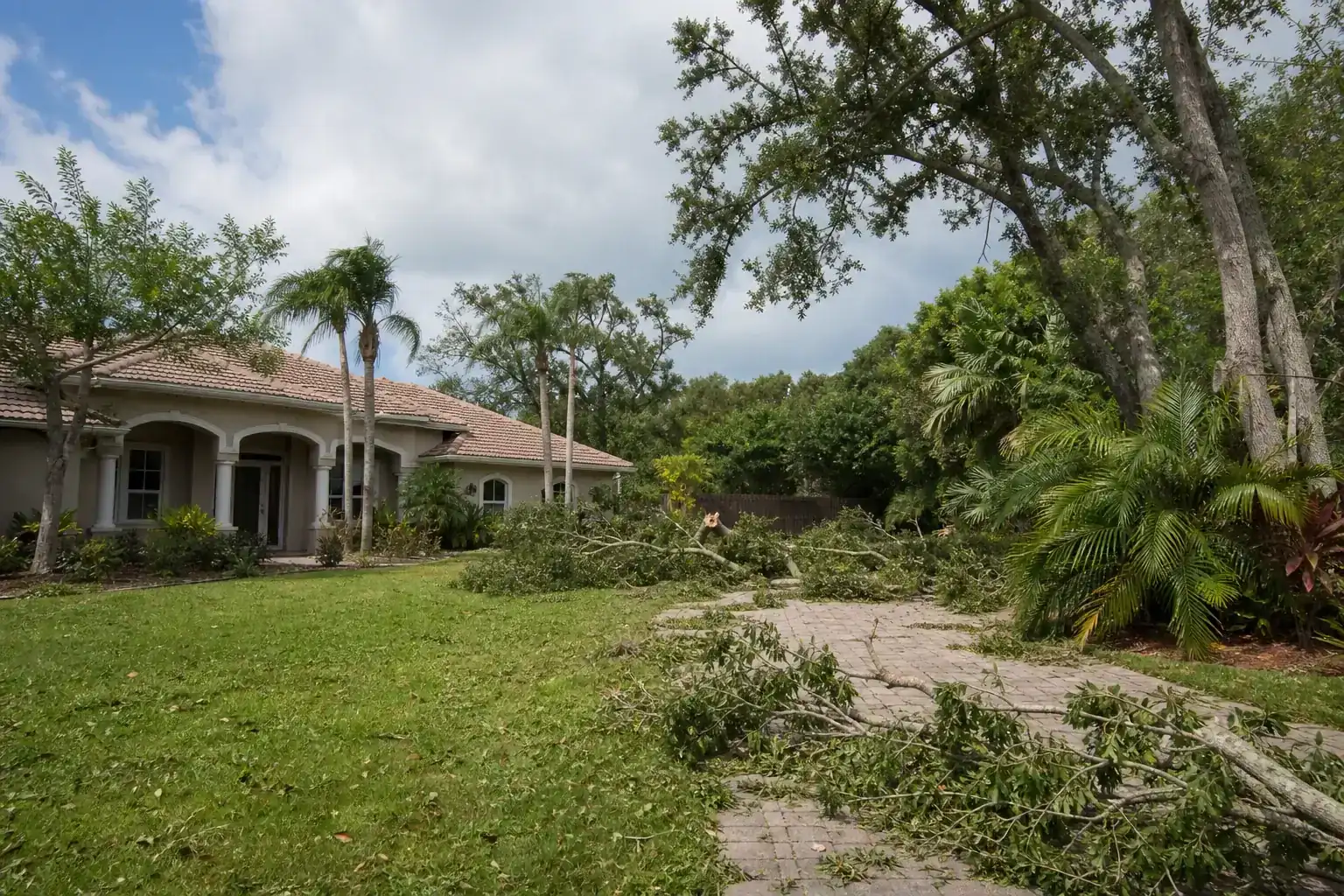 Storm-damaged branches beside a Florida home for hurricane tree trimming in central florida | be prepared